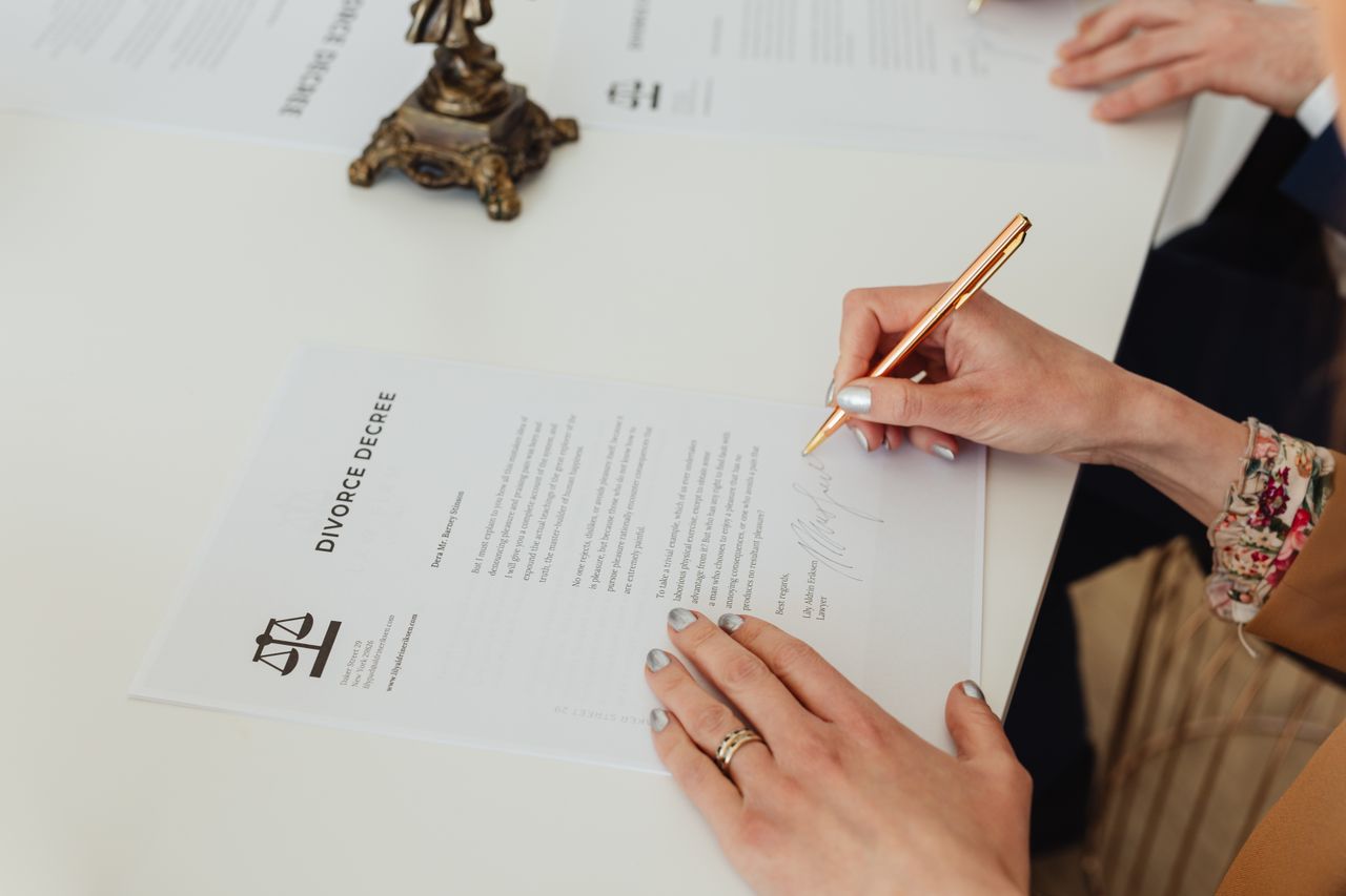 Close-up of hands signing a carefully negotiated legal agreement.